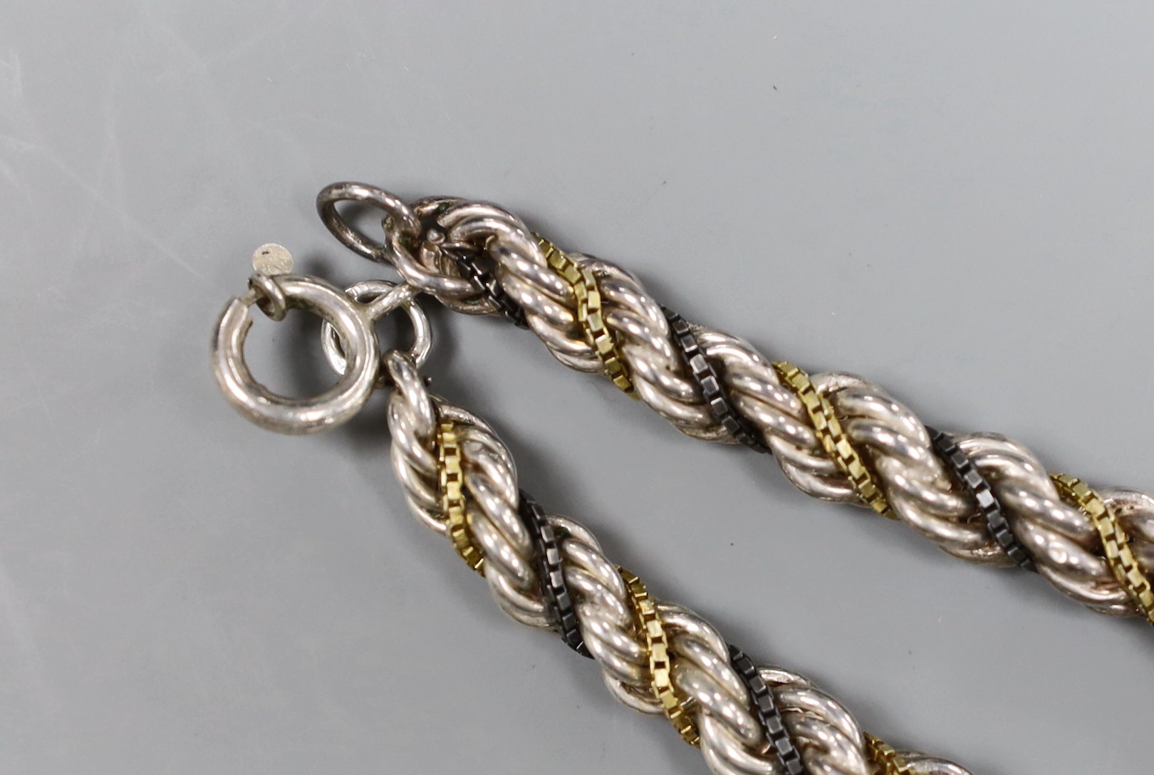 A Continental white metal, gilt and oxidised metal three strand ropetwist chain necklace, 50cm